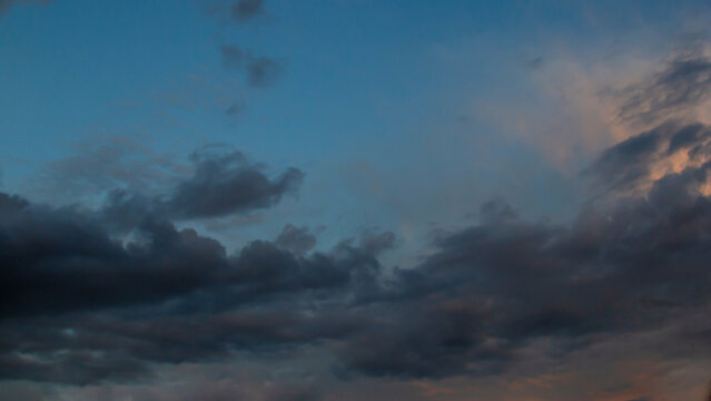 Calm Dusk Sky With Clouds At Twilight, Soft Blue Glow And Orange Hues