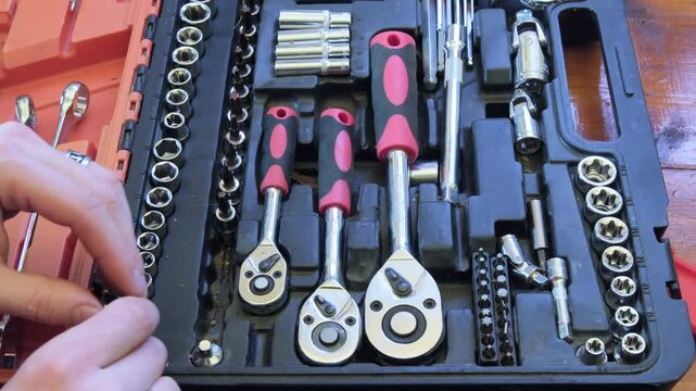 Picking tools from a toolbox for a home repair project in the garage during the weekend afternoon