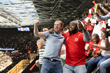 Excited diverse supporters jumping after winning live bet result, stadium crowd with adrenaline enjoying team victory. Happy fans celebrate successful sports betting with raised fists, lucky win. © DC Studio