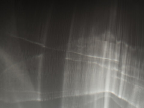 Shimmering caustics on black background. Abstract caustic light patterns created by refraction and reflection on a transparent surface. Can be used as overlay elements for design projects. 
