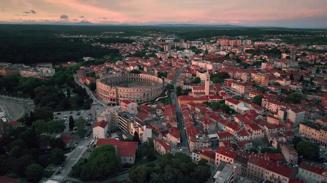 Cinematic aerial drone footage of Pula featuring historic architecture, Adriatic coastline, marina, and Mediterranean atmosphere. Scenic coastal views and ancient Roman heritage .
