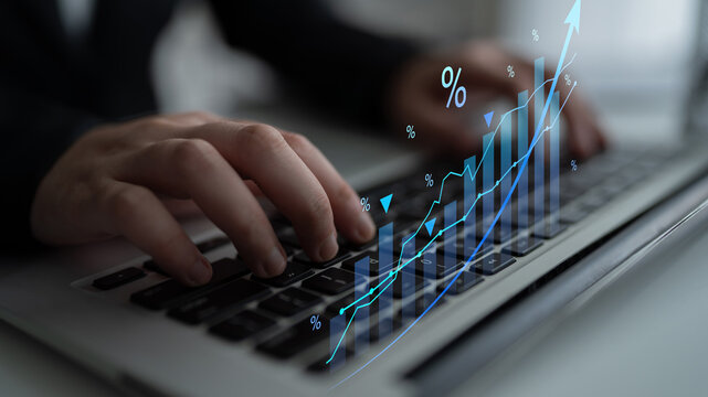 A business professional is engaged in financial analysis using a laptop, featuring a dynamic graph and percentage indicators, highlighting growth trends in a modern office setup. Cyphers