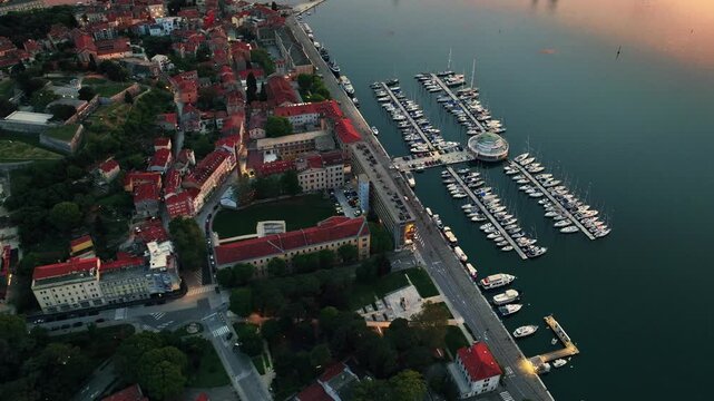 Cinematic aerial drone footage of Pula featuring historic architecture, Adriatic coastline, marina, and Mediterranean atmosphere. Scenic coastal views and ancient Roman heritage .