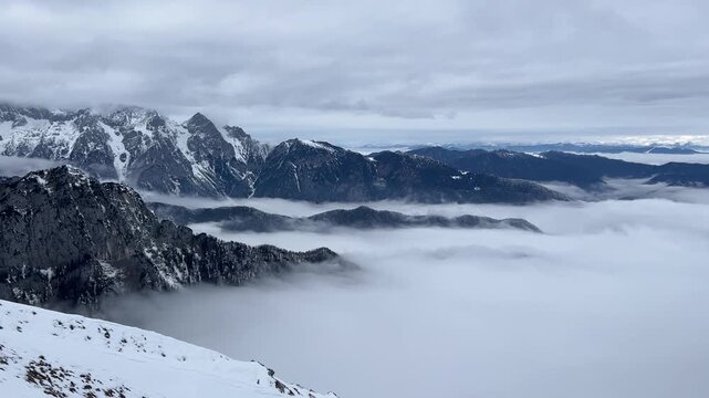 Hiker ascending the snow-covered slopes of Debela Pec mountain in winter, Slovenia.