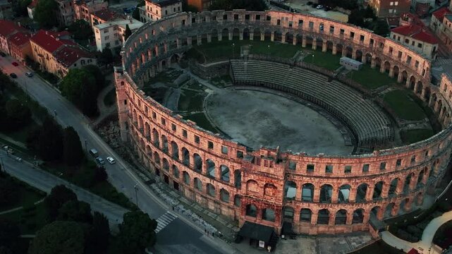 Cinematic aerial drone footage of Pula featuring historic architecture, Adriatic coastline, marina, and Mediterranean atmosphere. Scenic coastal views and ancient Roman heritage .