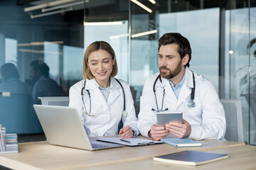 Doctors reviewing patient data and health records, using modern technology for efficient healthcare...