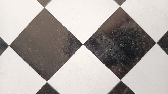 Abstract black and white diamond checker pattern background with visible scratches and grunge details