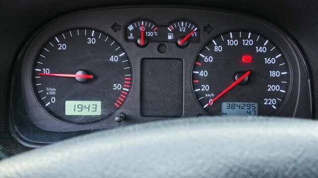 Car's instrument panel with blinking turn signal, showing the tachometer and speedometer needles moving