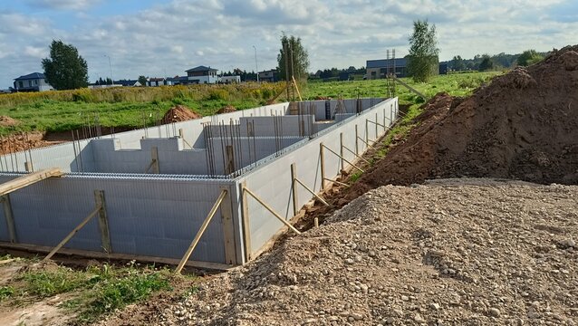 Construction site with ICF insulated concrete forms foundation walls for a modern residential house building project.