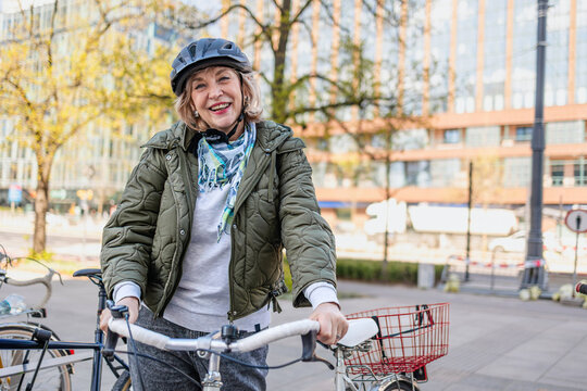 Senior woman wearing helmet while riding bicycle in the city
