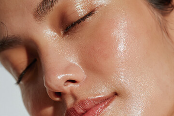 Fototapeta premium Radiant skin texture close up portrait glowing complexion natural beauty dewy skin healthy skin moisturized skin female face closed eyes soft lighting
