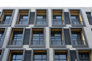 Fototapeta premium Modern minimalist style apartment building facade with windows and balconies