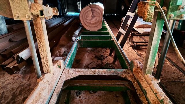 Old Band Saw in sawmill with log on rails in slow motion closeup