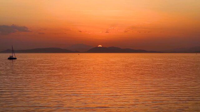 Aerial boat or captains point of view sailing over the calm ocean during a golden sunset as a background or texture
