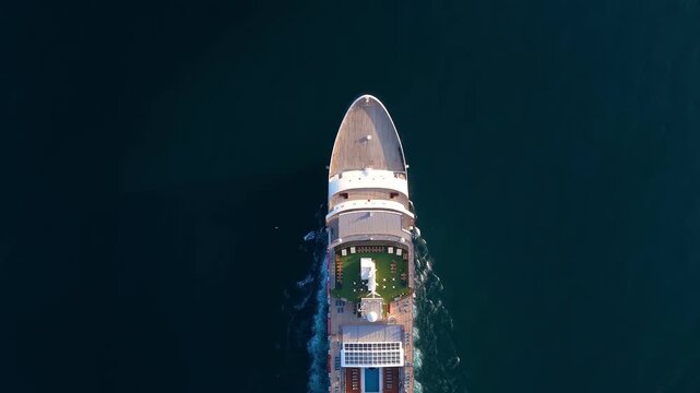 Aerial overhead view of the bow of a cruiseship traveling over the ocean during sunset time