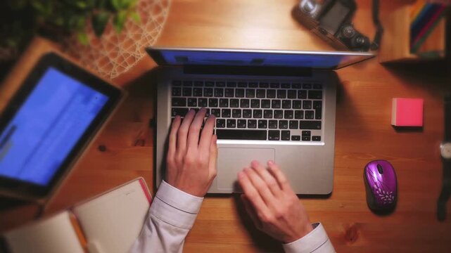 Top View of Person Working on Laptop at Wooden Desk with Digital Devices 4K