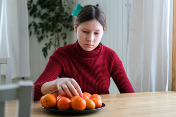 Fototapeta premium Teenager girl with depression sitting alone in the home room. Upset teenage girl suffering from stress for education. Crying for fail or bullying. Sad, anxiety. Mental health in adolescence concept.