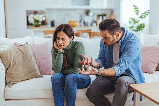 Upset Couple Having Intense Argument On Sofa In Living Room, Relationship Conflict And Misunderstanding