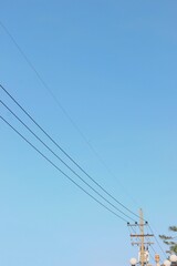 Fototapeta premium electric power lines against clear blue sky background