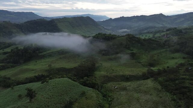Cinematic drone view of sunrise illuminating rural mountains and fog in Boyac&aacute;