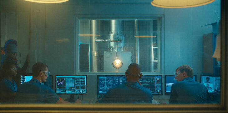 Modern industrial control room with operators monitoring complex systems on multiple digital screens monitors computer monitoring industry technology operators technicians surveillance