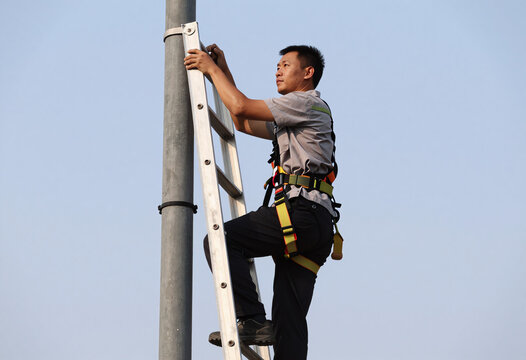 5G Tower Repairman with Safety Harness