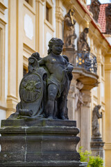 Naklejka premium Bronze Cherub Statue in Front of Historic Baroque Building