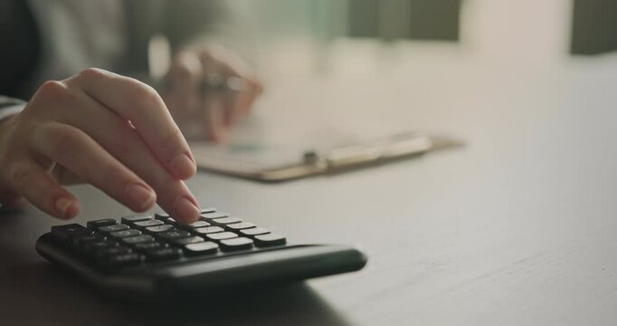 Close-up view woman's hand using a calculator