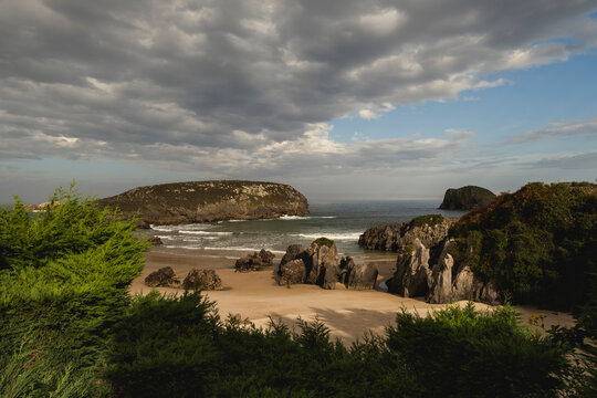 Wild beach with fine white sand and rocky outcrops in the coast of Llanes, Costa Verde,  Eastern Coast of Asturias, Spain