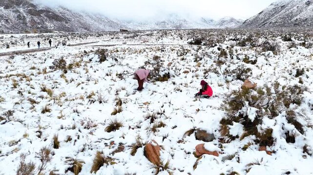 aerial view of children playing with snow in the mountains