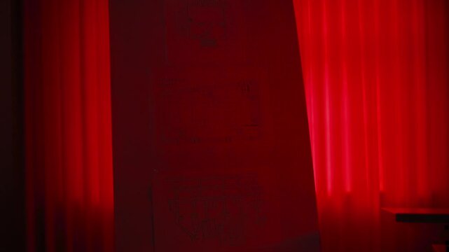 Empty flip chart and table in a dark room illuminated by a mysterious and dramatic red light