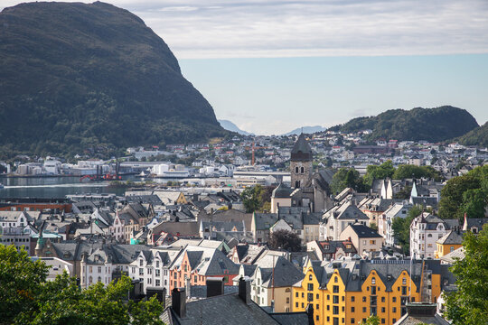 Alesund, a picturesque coastal town in Norway, featuring the mountain Sukkertoppen on Hessa island in the background