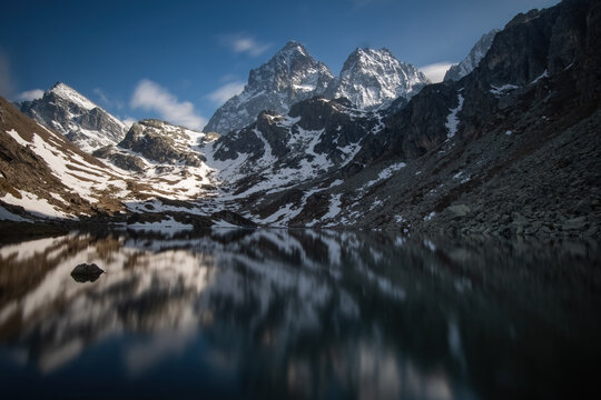 The Monviso mountain range (or Mount Viso) reflected in the crystal-clear waters of Lake Fiorenza at sunset on a spring day, Monviso Natural Park, Po Valley, Piedmont, Italy.