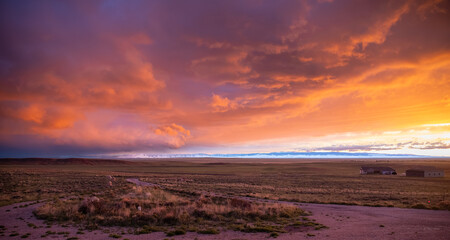 Obraz premium Dramatic orange sunset sky over a vast high plains landscape and mountains, Laramie, Wyoming