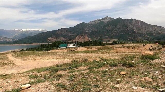 Scenic panning shot of Charvak reservoir lake and mountains in Uzbekistan