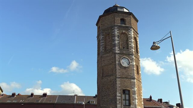 Historic stone clock tower near marina waterfront in Dunkirk France
