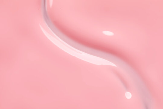 Pink nail polish as background, top view