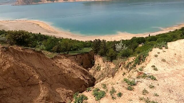 Scenic panning shot of a deep clay ravine near Charvak reservoir in Uzbekistan