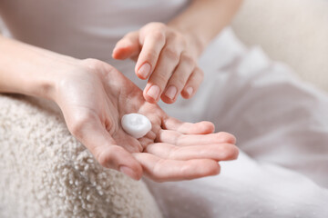 Fototapeta premium Woman applying hand cream at home, closeup