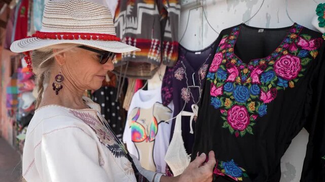 Mature woman enjoys shopping for clothes and tasting local food in Mulege Baja California Sur in Mexico by the Sea of Cortez.