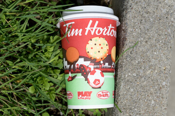 Fototapeta premium Tim Hortons soccer themed beverage cup discarded outside, Toronto