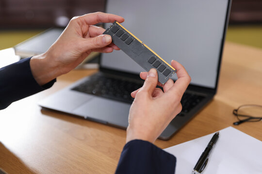 Woman with SD RAM at wooden desk, closeup