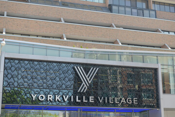 Naklejka premium exterior building facade and sign of Yorkville Village, a shopping mall, located at 55 Avenue Rd, Toronto