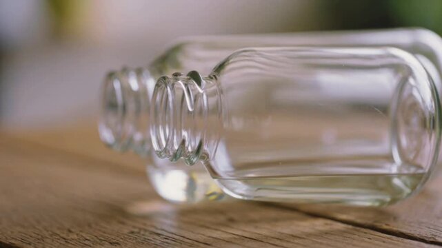 Frascos de vidrio transparente vac&iacute;os sobre madera r&uacute;stica para cosm&eacute;tica natural