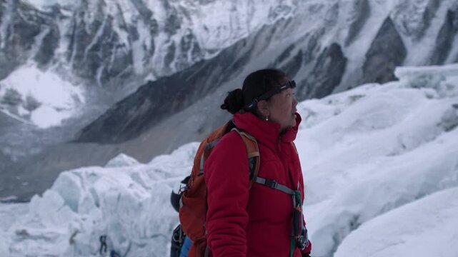 Female Sherpa climber carefully ascending a dangerous glacier on a Himalayan expedition