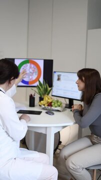 Vertical screen dietologist explains popular healthy plate method during nutrition consultation while young woman studies balanced meal proportions on digital screen