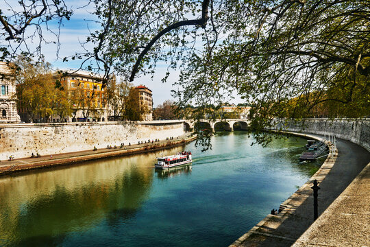 White tour boat traveling through the Tiber river, Rome, Italy, Europe