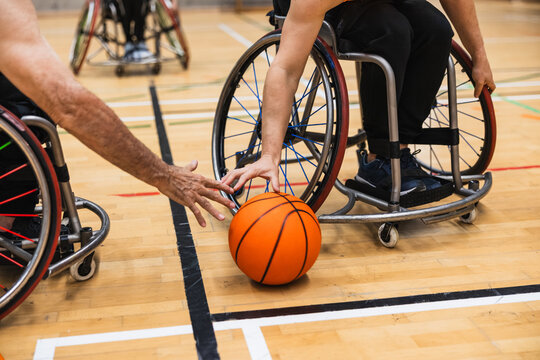 Athletes playing wheelchair basketball game on court