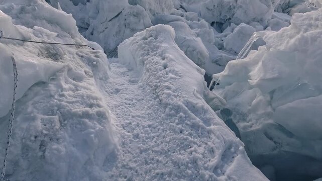 Point of view of a mountaineer abseiling down a steep icy crevasse on a high mountain glacier