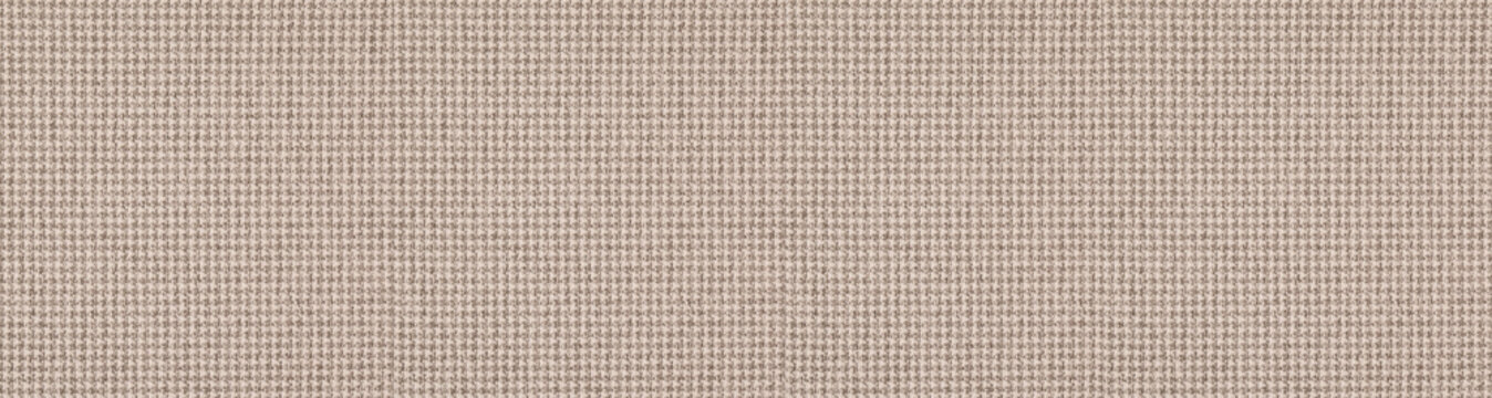 Warm beige woven tweed fabric background revealing a detailed houndstooth and checkered textile pattern for elegant tailoring.